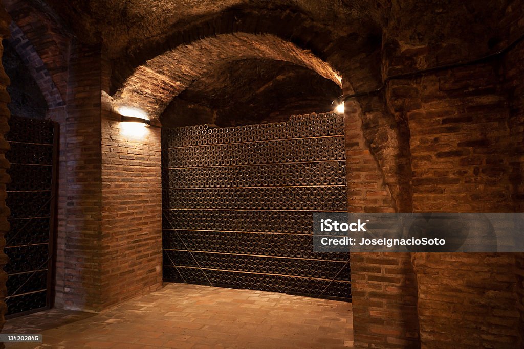 Viejo y sucio botellas de vinos en una bodega de antigüedad de apilado - Foto de stock de Bodega - Almacén libre de derechos