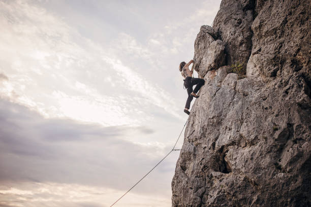 istock Athletic male rock climbing on the cliff 1342028698