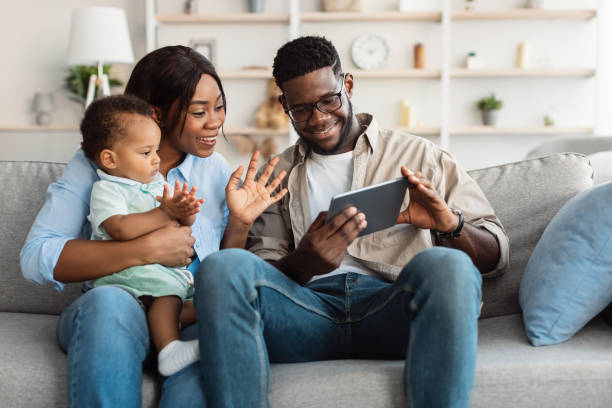 istock Black family having videocall using tablet waving hands 1342028950