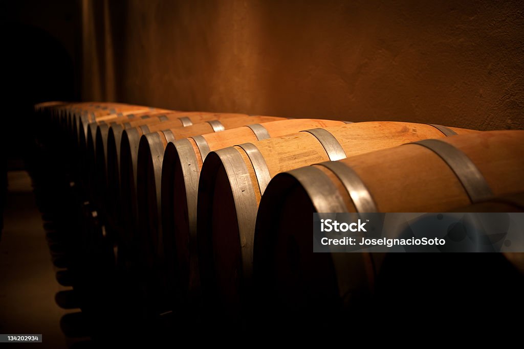 Fila de barriles de vino en bodega de antigüedad - Foto de stock de Barril de vino libre de derechos