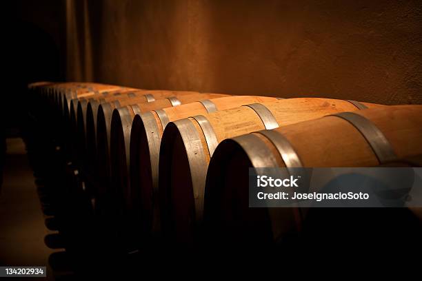 Fila De Barriles De Vino En Bodega De Antigüedad Foto de stock y más banco de imágenes de Barril de vino - Barril de vino, Sótano almacén, Anticuado