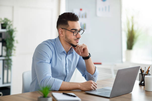 istock Positive Arab businessman using laptop pc at workplace, speaking to colleagues on webcam 1342030070