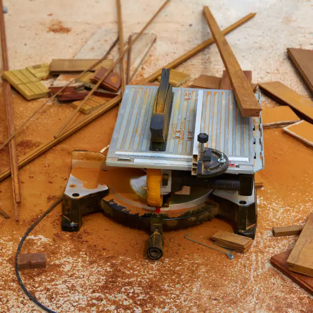 Circular table saw carpenter tool and sawdust in deck installation