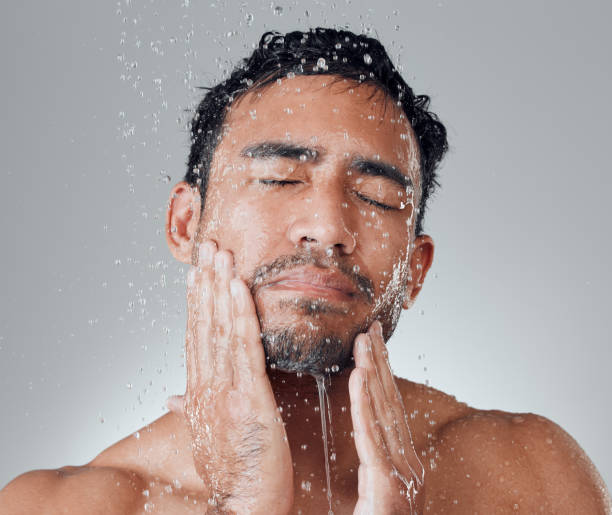 istock Shot of a young man taking a shower against a grey background 1342032505