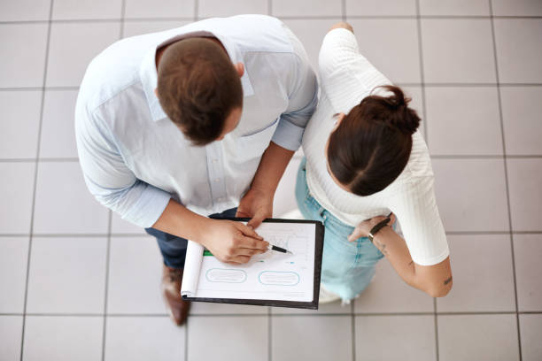 istock Shot of a customer reading over paperwork with her salesman 1342035908