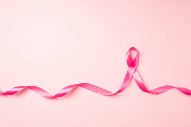 photo de la vue de dessus du ruban de satin rose bouclé symbole de la sensibilisation au cancer du sein sur fond rose pastel isolé avec espace vide - lutte contre le cancer du sein photos et images de collection
