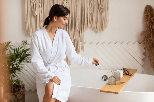istock Lady Choosing Cosmetics On Shelf Sitting On Bathtub In Bathroom 1342037629