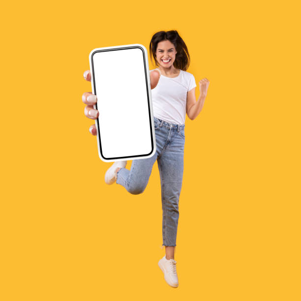 istock Woman showing white empty smartphone screen and jumping up 1342037858