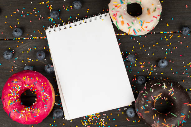 istock On a wooden background, blank notepad, colorful donuts and blueberries. Creative cuisine. 1342037932