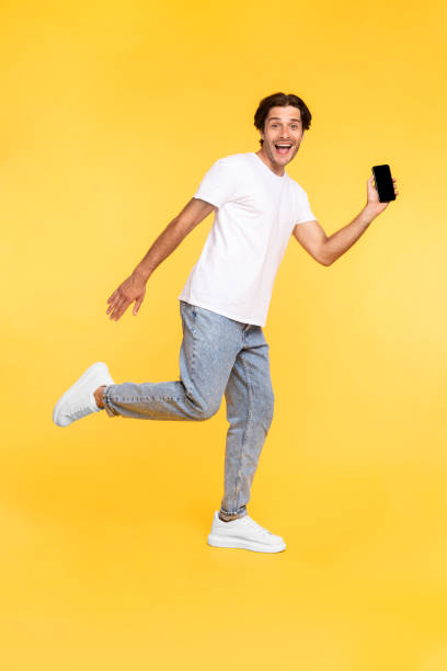 istock Man showing white empty smartphone screen and jumping 1342038214