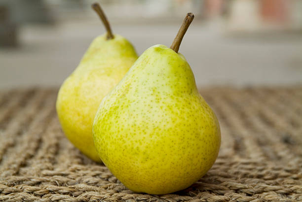 Bartlett Pears Two Bartlett Pears on sisal. Focus on front pear. bartlett pear stock pictures, royalty-free photos & images