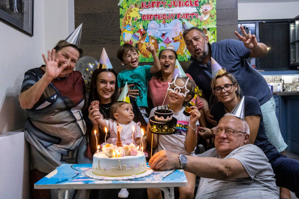 Birthday party with the family during COVID-19. Blowing candles on a birthday cake. A 9-year-old girl celebrates with the whole family and cousins in pandemic times. happy birthday cousin stock pictures, royalty-free photos & images