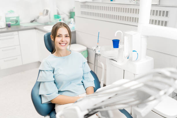 Closeup side view of a cheerful woman sitting in a chair Closeup side view of a cheerful woman sitting in a chair dentists chair stock pictures, royalty-free photos & images