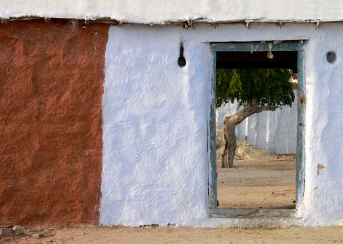 Traditional wall and intrance to the yard with small houses where more families live. Place: The village Chandelao in the desert in Rajasthan, India.  