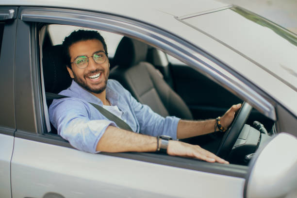 istock Cheerful arab guy driving right wheel car 1342039504