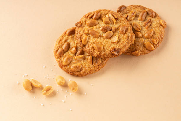 istock Cookies with roasted peanuts on top on beige background. 1342042413