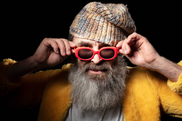 istock Fashionable elderly bearded man in bright clothes on a black background. 1342042784