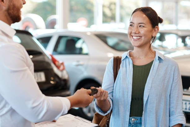 shot of a car salesman handing over keys to a customer - 汽車經銷商陳列室 個照片及圖片檔