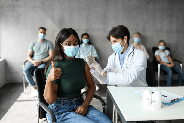 istock Young black lady in face mask getting vaccination at clinic 1342043932