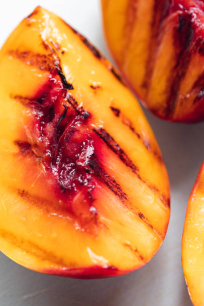 istock Juicy grilled nectarine quarters on light gray cutting board. 1342045540