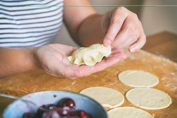 istock Making dumplings filled with sour cherry with sugar 1342047263