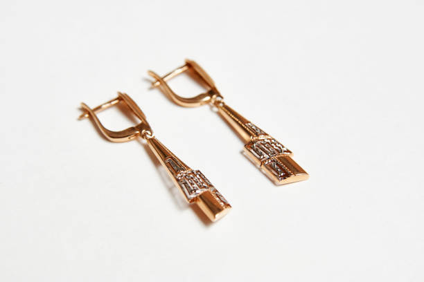 istock Golden earrings on white background with copy space 1342047317