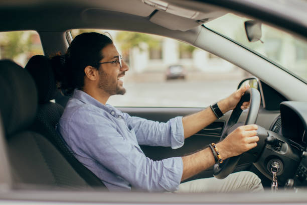 istock Handsome indian guy driving car, looking at road and smiling 1342050132
