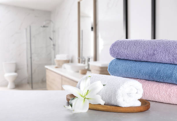 istock Fresh towels and lily flower on light grey marble table in bathroom. Space for text 1342051948