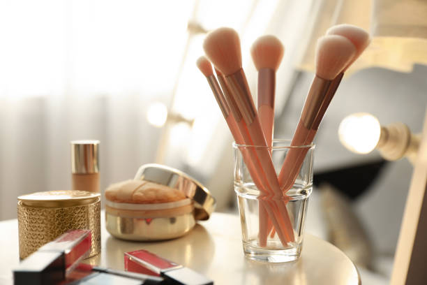 istock Makeup products and set of cosmetic brushes on table indoors. Interior element 1342052957
