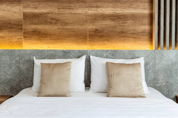 Close up cozy pillow on white double bed in minimal master bedroom