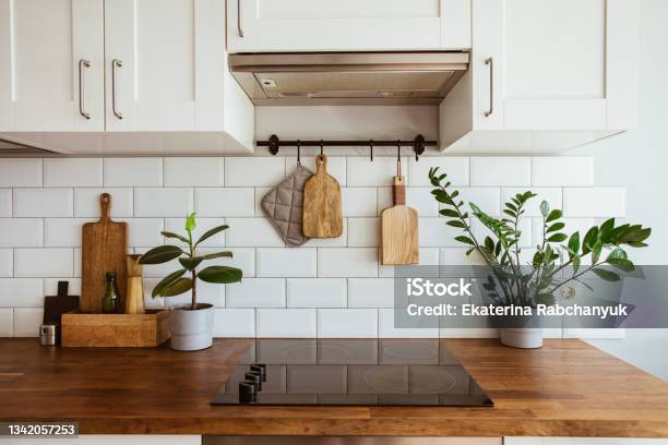 Kitchen Brass Utensils Chef Accessories Hanging Kitchen With White Tiles Wall And Wood Tabletopgreen Plant On Kitchen Background Stock Photo - Download Image Now