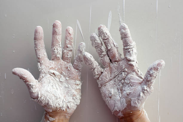 istock Astist plastering man hands with cracked plaster 1342059205