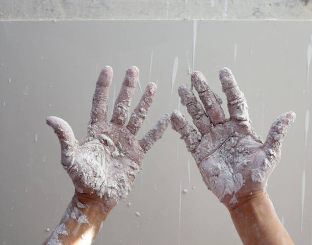 istock Astist plastering man hands with cracked plaster 1342059211
