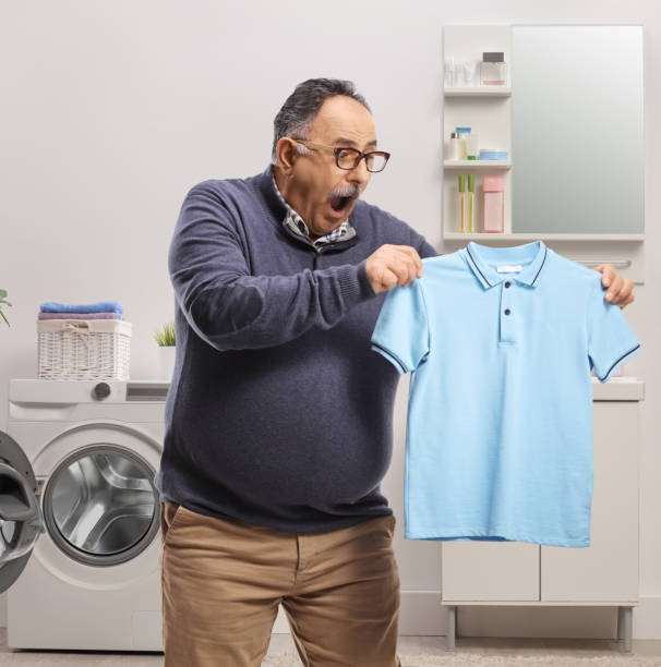 istock Shocked mature man holding a shrunken t-shirt 1342059243