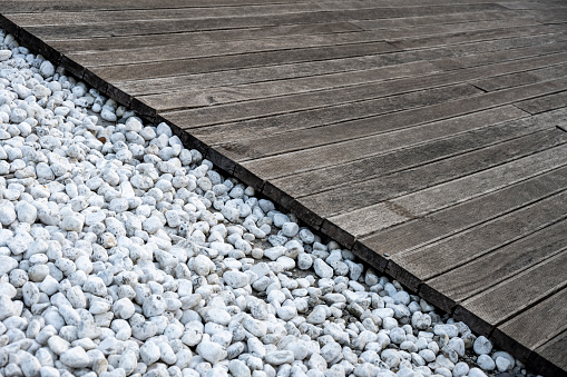 A walkway made of small white stones and wood.