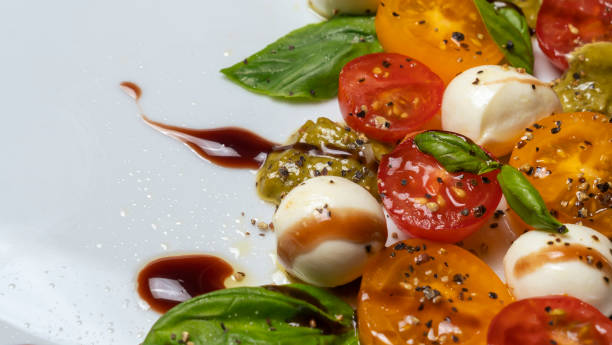 istock Caprese salad. Healthy meal with cherry tomatoes, mozzarella balls, spices, fresh rocket and basil. 1342061027