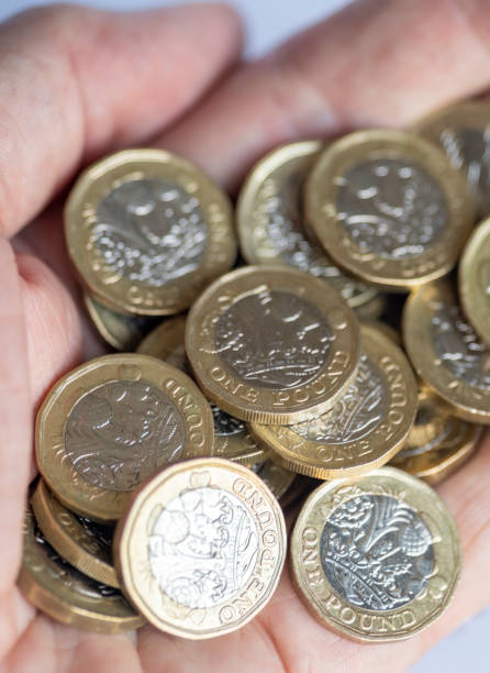 mano dell'uomo che tiene un sacco di monete da una sterlina - one pound coin british coin old uk foto e immagini stock