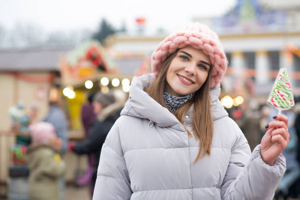 istock Stunning lady with candy on a christmas fair 1342062032