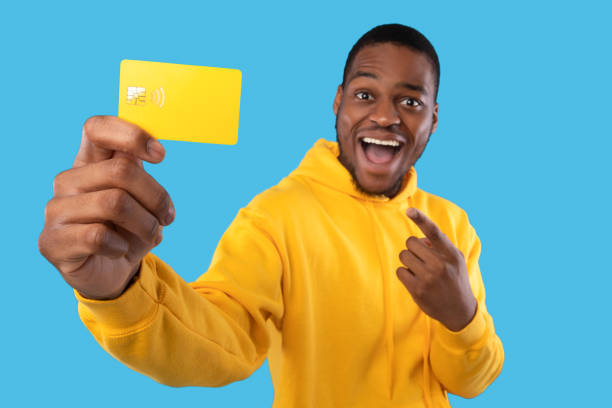 istock Excited Black Guy Showing Credit Card Posing Over Blue Background 1342062178