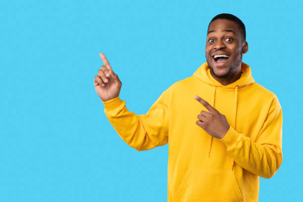 istock African Guy Pointing Fingers Aside Showing Blank Space, Blue Background 1342062256