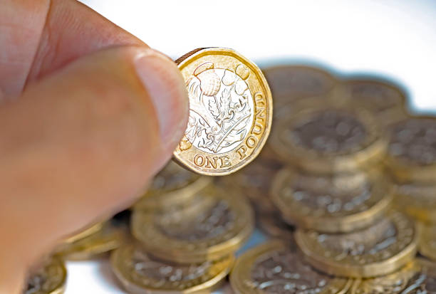 mano dell'uomo che tiene una moneta da una sterlina - one pound coin british coin old uk foto e immagini stock