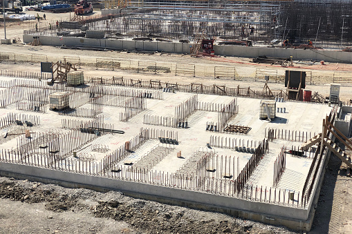 Reinforced concrete foundation and metal reinforcement outlets. Construction site of industrial building.