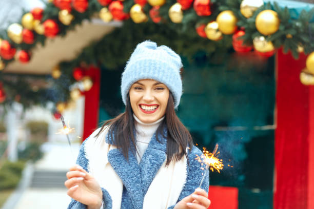 istock Joyful lady enjoying holidays with sparklers 1342064177