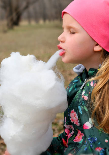 istock Child girl eating cotton candy 1342064552