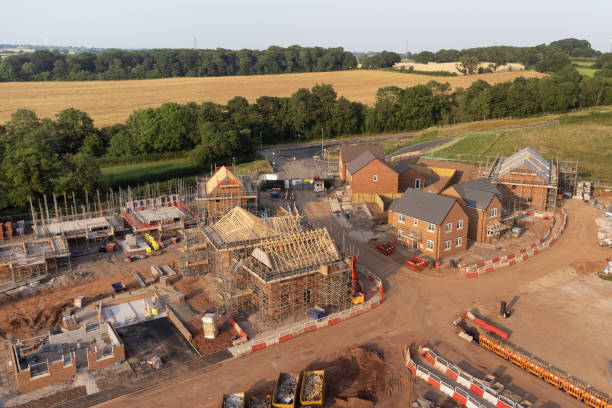 Aerial view of new build housing construction site in England, UK Aerial view looking down on new build housing construction site in England, UK housing development stock pictures, royalty-free photos & images