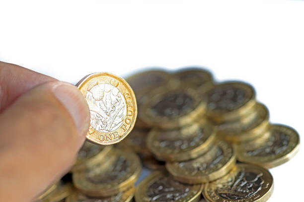 mano dell'uomo che tiene una moneta da una sterlina - one pound coin british coin old uk foto e immagini stock