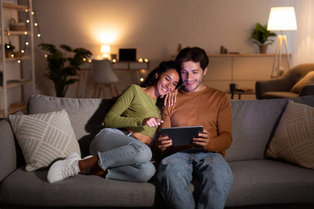 istock Couple Watching Film On Laptop Computer Sitting At Home 1342064969