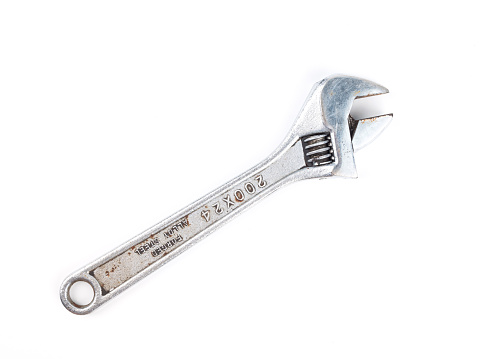 Old adjustable wrench isolated over white