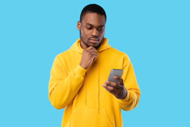 istock African American Guy Holding Smartphone Texting And Thinking, Blue Background 1342067277