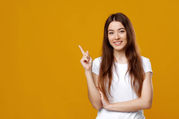 istock Cheerful lady posing over colorful background, pointing at copy space 1342068610